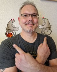 Das Bild zeigt einen Mann der mit beiden Händen auf seine Schultern zeigt. Auf seinen Schultern sind gezeichnet Seekuhengelchen und Seekuhteufelchen abgebildet.